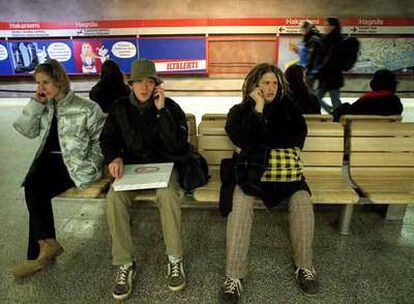 Unos jóvenes utilizan los teléfonos móviles en el metro de Helsinki.