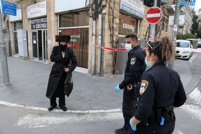 Dos agentes identifican a un ultraortodoxo en un acceso al barrio de Mea Shearim, el domingo en Jerusalén.