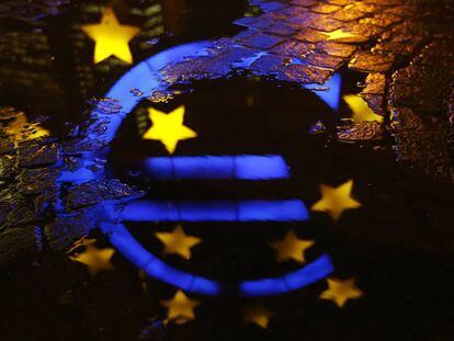 El s&iacute;mbolo del euro, reflejado en un charco junto a la sede del BCE, en Fr&aacute;ncfort (Alemania).