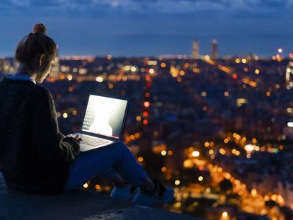 Una mujer trabaja con su ordenador en el exterior.