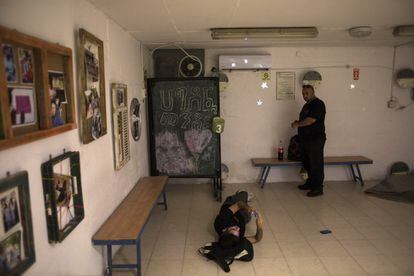 Dos israelíes se cobijan en refugios antibombas mientras dura la alarma por los ataques de Hamás.