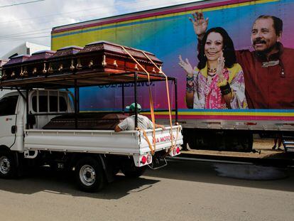 Un camión con féretros pasa por delante de un cartel de la pareja presidencial en Masaya, Nicaragua, el 2 de noviembre