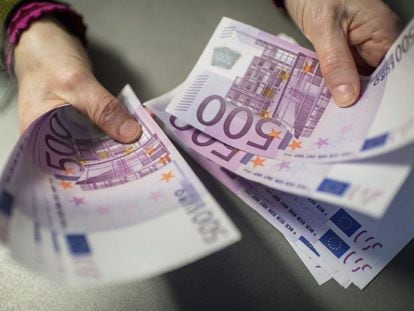 Un empleado de banca muestra billetes de 500 en una sucursal del banco Sparkasse en M&uacute;nich (Alemania).