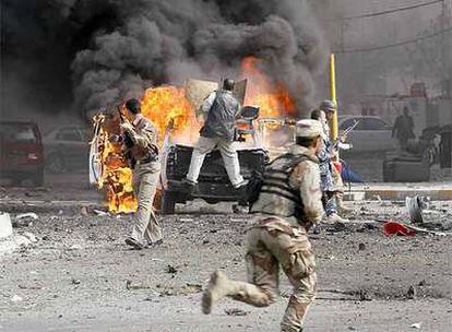Soldados iraquíes junto a un coche bomba instantes después de la explosión el jueves en Bagdad.