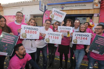 Varios trabajadores se reúnen a las puertas de la administración de lotería El Perolo, en San Pedro del Pinatar (Murcia).