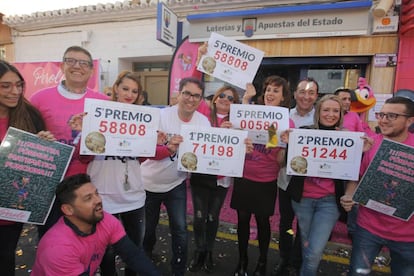 Varios trabajadores se reúnen a las puertas de la administración de lotería El Perolo, en San Pedro del Pinatar (Murcia).