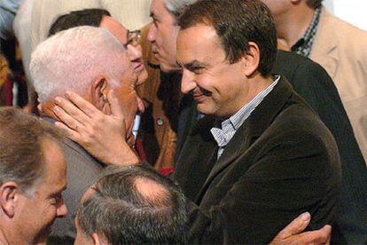 Zapatero saluda a un militante socialista gallego durante el acto de hoy en Santiago.
