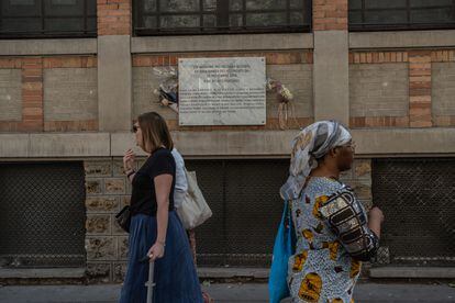 Viandantes en París pasean delante de las placas que recuerdan a las víctimas del atentado de noviembre de 2015.