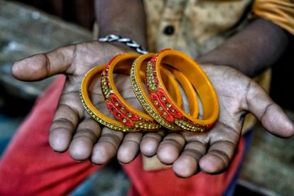 Roja muestra unos brazaletes parecidos a los que confeccionaba en la fábrica de Jaipur, en Rajastán, incrustando pequeñas piezas decorativas.