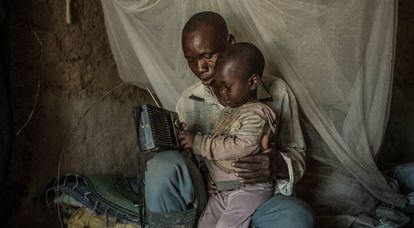 Nabonswendé y su hijo encienden la radio en casa.