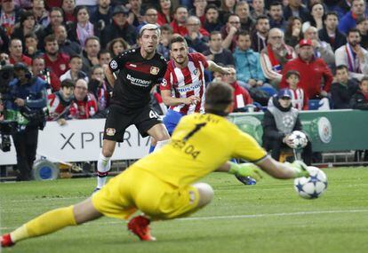 El centrocampista del Atlético de Madrid Koke Resurreción (derecham a fondo) dispara a puerta entre el esloveno Kevin Kampl (izquierda, al fondo) y el portero Bernd Leno, del Bayer Leverkusen.