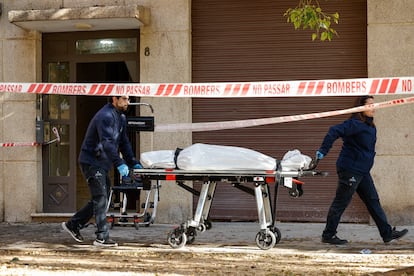 Operarios del retén fúnebre salen con un cadáver del edificio donde se ha declarado un incendio a primera hora de este lunes en la ciudad de Valencia.