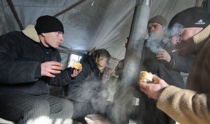 Un grupo de personas sin hogar recibe comida y bebida caliente en la localidad ucrania de Lviv, en el centro del país.