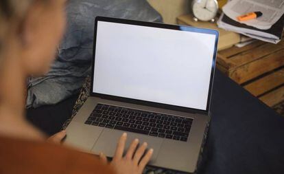 Una mujer, ante una pantalla en blanco del ordenador.