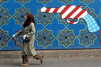 Una mujer iraní pasa ante una pintada antiamericana en la antigua Embajada de EE UU en Teherán