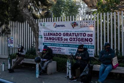Familiares de enfermos esperan formados un  turno para poder recargar sus tanques de oxigeno en la explanada de la delegación de Iztapalapa.
