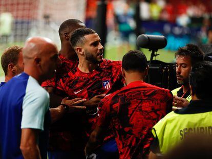 Mario Hermoso es sujetado por miembros del cuerpo técnico del Atlético tras su enfrentamiento con los ultras rojiblancos en el Metropolitano al término del partido con el Villarreal disputado el pasado domingo.