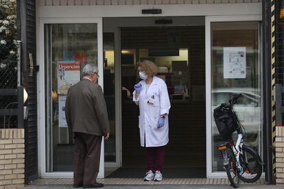 Una sanitaria espera este sábado a los pacientes a la puerta de un centro de salud en Madrid.