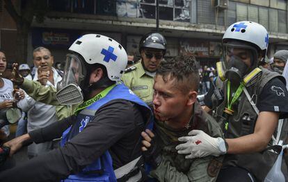 Paramédicos rescatan a un miembro de la Guardia Nacional Bolivariana (GNB) herido durante los enfrentamientos con manifestantes en Caracas.