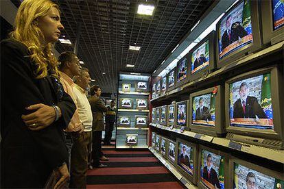 Un grupo de brasileños sigue el discurso de Lula en las pantallas de un centro comercial de São Paulo.