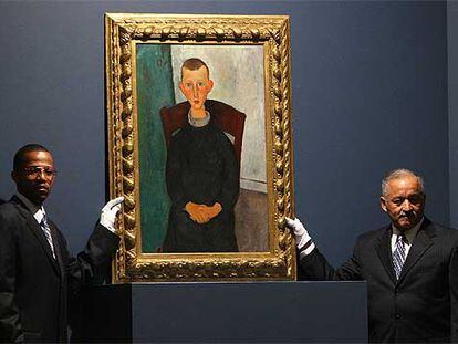 Dos empleados de Sotheby&#39;s muestran <i>El hijo del portero</i><b> (Modigliani).