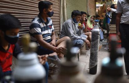 Varias personas esperan para rellenar sus botellas de oxígeno en una tienda de Nueva Delhi. 