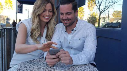 Una pareja utiliza un teléfono móvil.