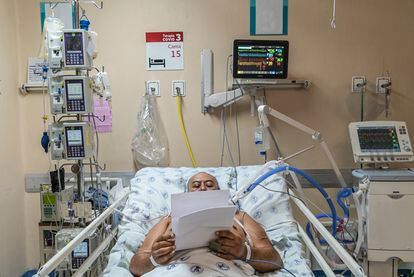 Don Fernando, el único paciente despierto en la unidad de terapia intensiva del Hospital Juárez en Ciudad de México, lee mensajes de apoyo de familiares y amigos. La soledad es una de las partes más difíciles para quienes están internados y la incertidumbre, para quienes esperan fuera. 25 de mayo de 2020.