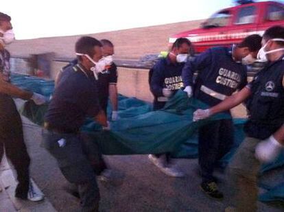 Agentes de la guardia costera italiana trasladan el cadáver de un inmigrante en Lampedusa.