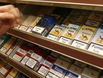Un estanquero se dispone a coger un paquete de cigarrillos en un despacho de tabaco de París.