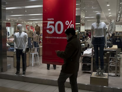 Una persona pasa por una tienda en un centro comercial en Santiago, en 2022.