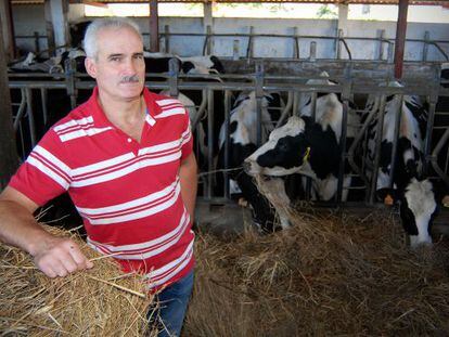 Manuel Pu&ntilde;al posa ante las vacas de orde&ntilde;o de su granja, en el municipio coru&ntilde;&eacute;s de Ponteceso.