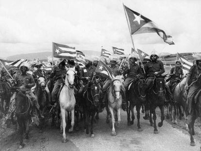 El revolucionario Camilo Cienfuegos porta una gran bandera de Cuba en una marcha de campesinos en 1959. 