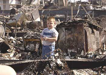 Un niño observa los restos de su casa arrasada por el fuego en la localidad de Crest, cerca de San Diego.