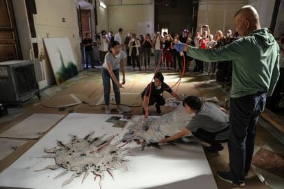 Cai Guo Qiang, en el Salón de Reinos, trabajando con su equipo en la obra 'El alquimista', basada en una antigua leyenda en la que un león se quería comer el Sol, lienzo que formará parte de la exposición, 'El espíritu de la pintura', que se inaugura el 25 de octubre en el Museo del Prado. Él controla todo el proceso, pero sus colaboradores le ayudan a situar las plantillas, los cables, la pólvora, los pesos para que todo se mantenga en su sitio durante la explosión.