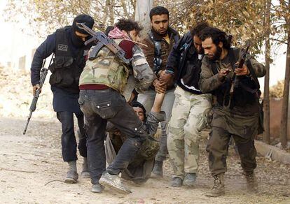 Milicianos del Ej&eacute;rcito Libre Sirio evacuan a un compa&ntilde;ero herido en la batalla en Alepo. 