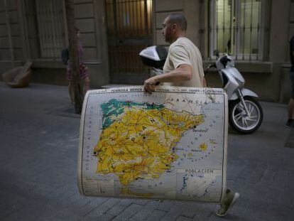 Un hombre, con un mapa de Espa&ntilde;a en el centro de Barcelona.