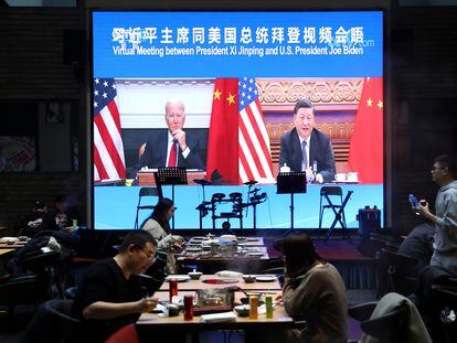 Le reunión entre los presidentes de China, Xi JInping, y EE. UU, Joe Biden, se muestra en la pantalla de un restaurante de Pekín este martes