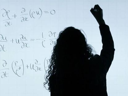 Una mujer resuelve un problema matemático en una pizarra.