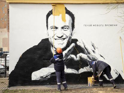 Trabajadores municipales tapan un grafiti del líder opositor ruso Alexéi Navalni, en el que se puede leer "héroe de nuestro tiempo", en San Petersburgo el pasado mes de noviembre.
