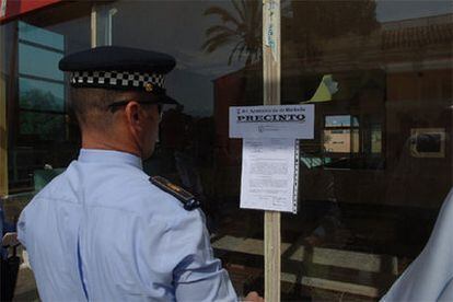 Un agente de la Policía Local observa el precinto ordenado por la gestora de Marbella.