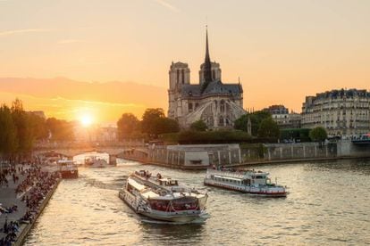 Cruceros tur&iacute;sticos en el r&iacute;o Sena, en Par&iacute;s, con la catedral de Notre Dame al fondo. 