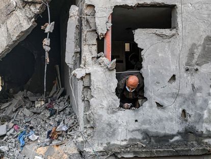 Un hombre se asoma entre los escombros de una casa destruida por un bombardeo israelí en Gaza.
