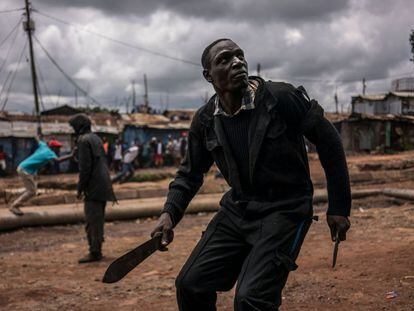 Un manifestante se enfrenta a la policía con un machete y un cuchillo durante las protestas en el barrio de Kibera, Nairobi.