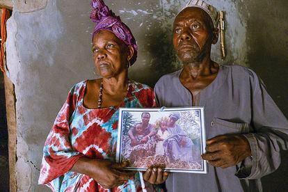 Los padres de Candé, retratados en mayo pasado en su aldea de Guinea-Bisáu sosteniendo una foto en la que aparece Aliou.