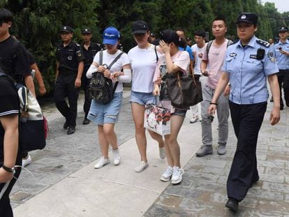 La policía escolta en Pekín a varios manifestantes afectados por las pérdidas de las plataformas P2P. 