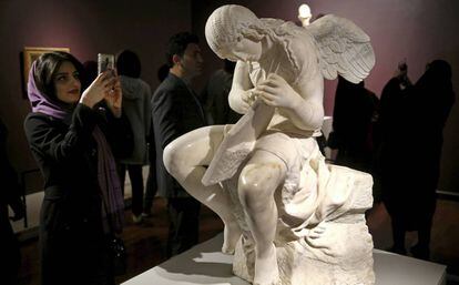 Una mujer junto a la escultura 'Funerary Genius' en la exposición 'El Louvre en Teherán', inaugurada el 5 de marzó en Teherán.