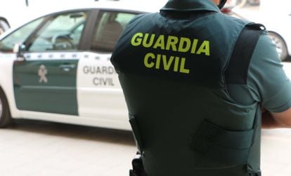 Un agente de la Guardia Civil, de espaldas, junto a un vehículo oficial en una imagen de archivo.