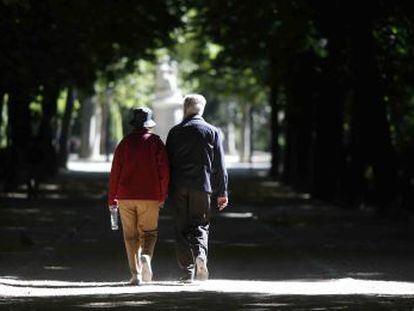 Dos jubilados pasean por el parque del Retiro en Madrid.