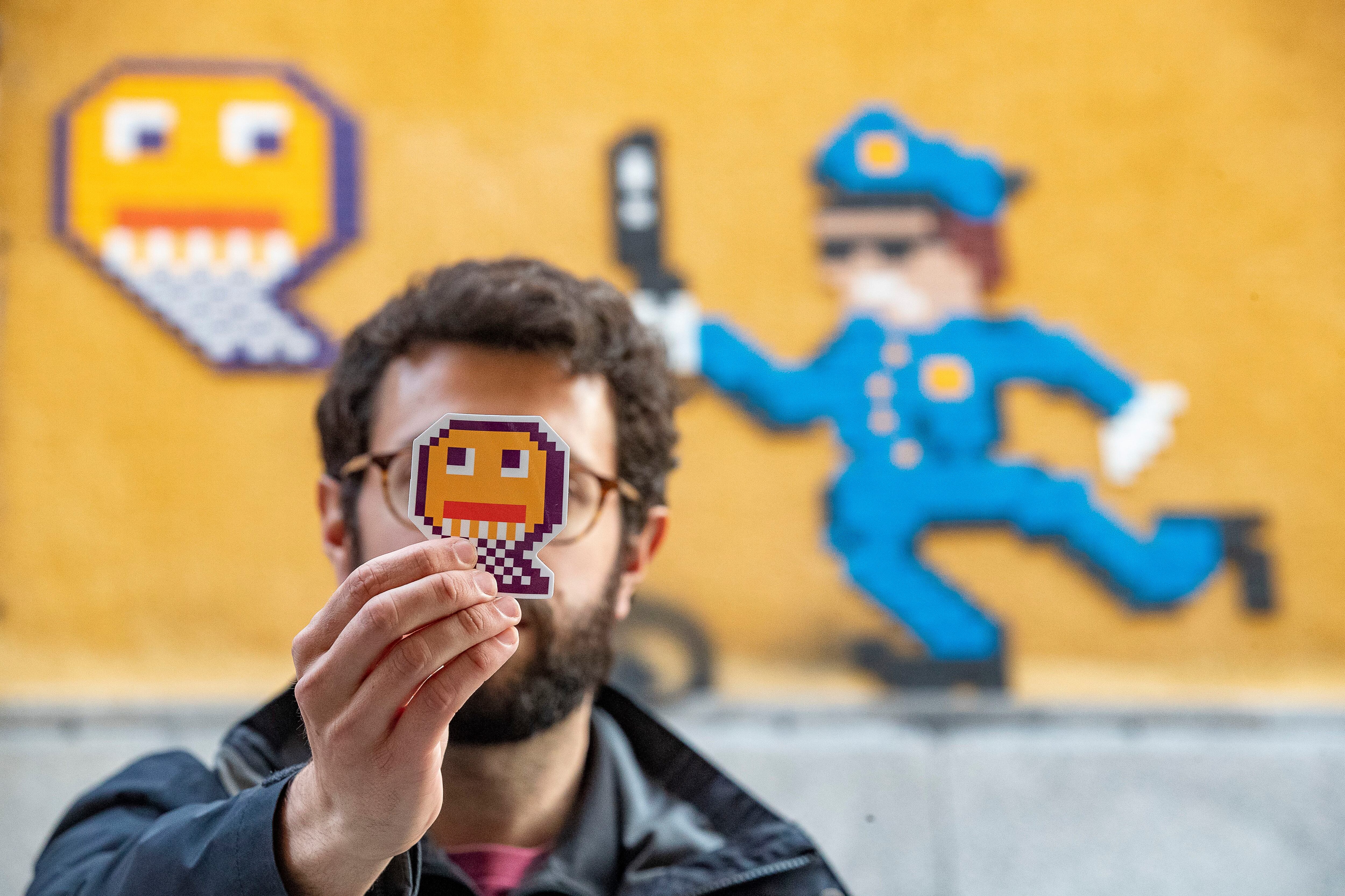 El artista urbano anónimo Nean delante de una de sus intervenciones en Malasaña